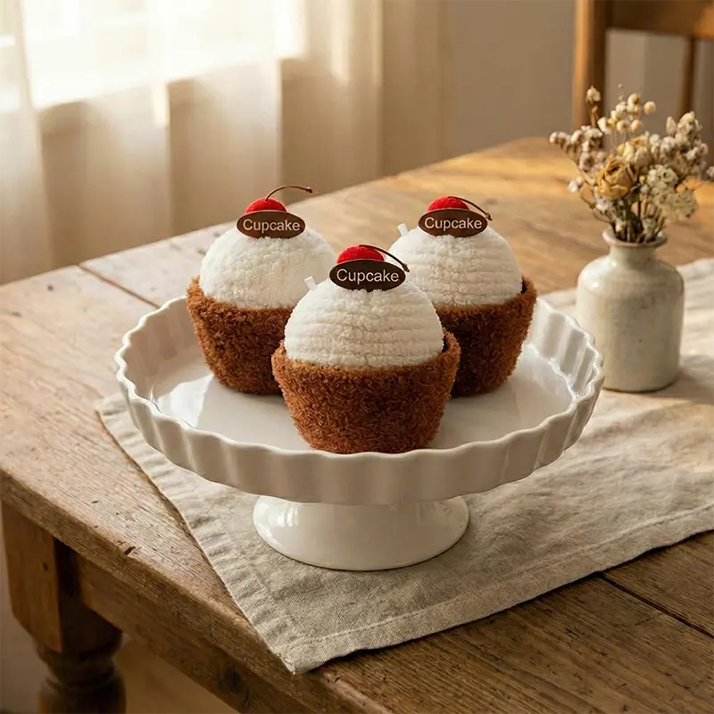 Peluche gâteau cupcake gourmande style Jellycat, base marron douce, glaçage blanc moutonné, cerise.