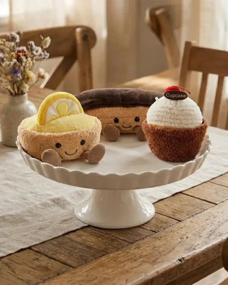 Peluche gâteau cupcake gourmande style Jellycat, base marron douce, glaçage blanc moutonné, cerise.